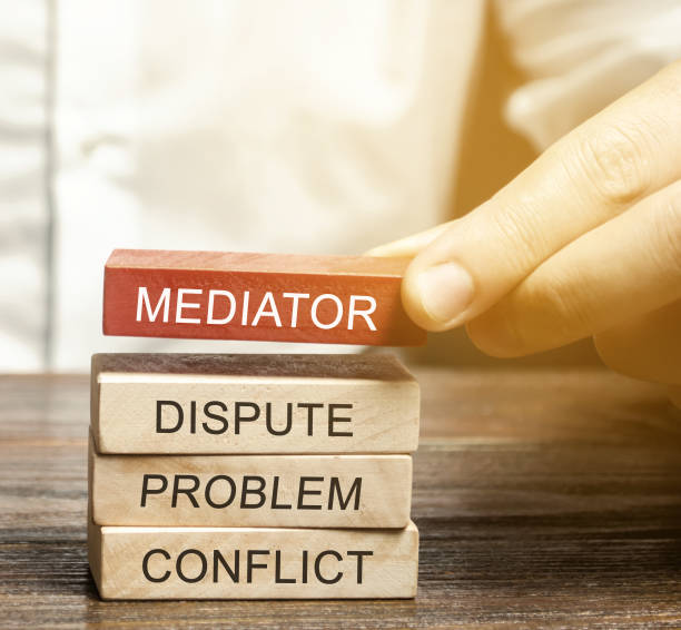 A man holds wooden blocks with the word Mediator, dispute, problem, conflict. Settlement of disputes by mediator. Dispute Resolution and Mediation. Third party, intermediary.